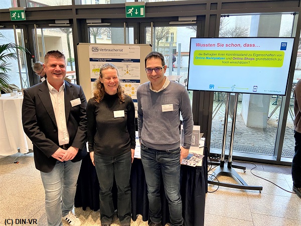 Drei Personen stehen am Stand des DIN-Verbraucherrats beim "Safer Internet Day"