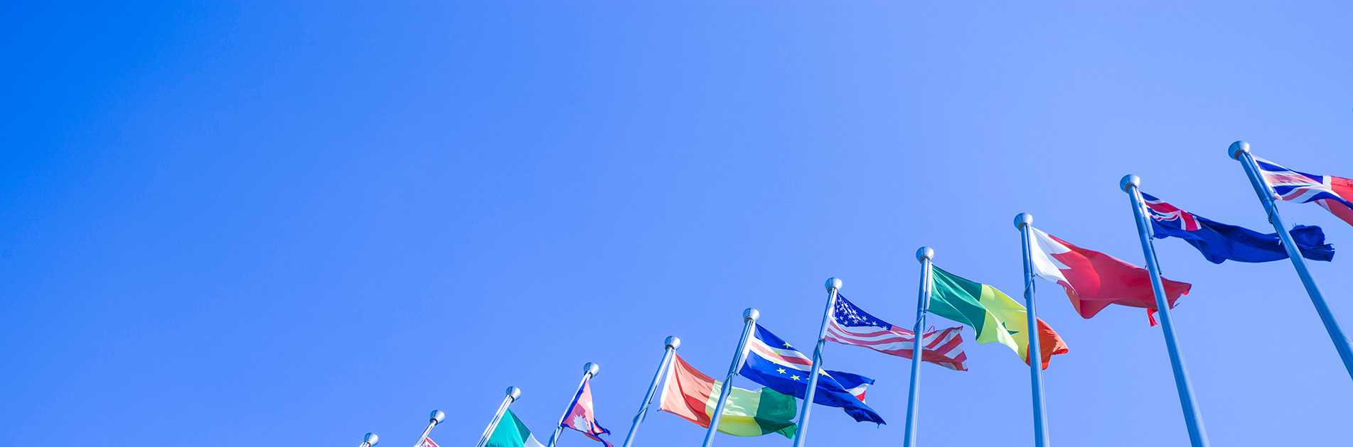Internationale Flaggen vor blauem Himmel