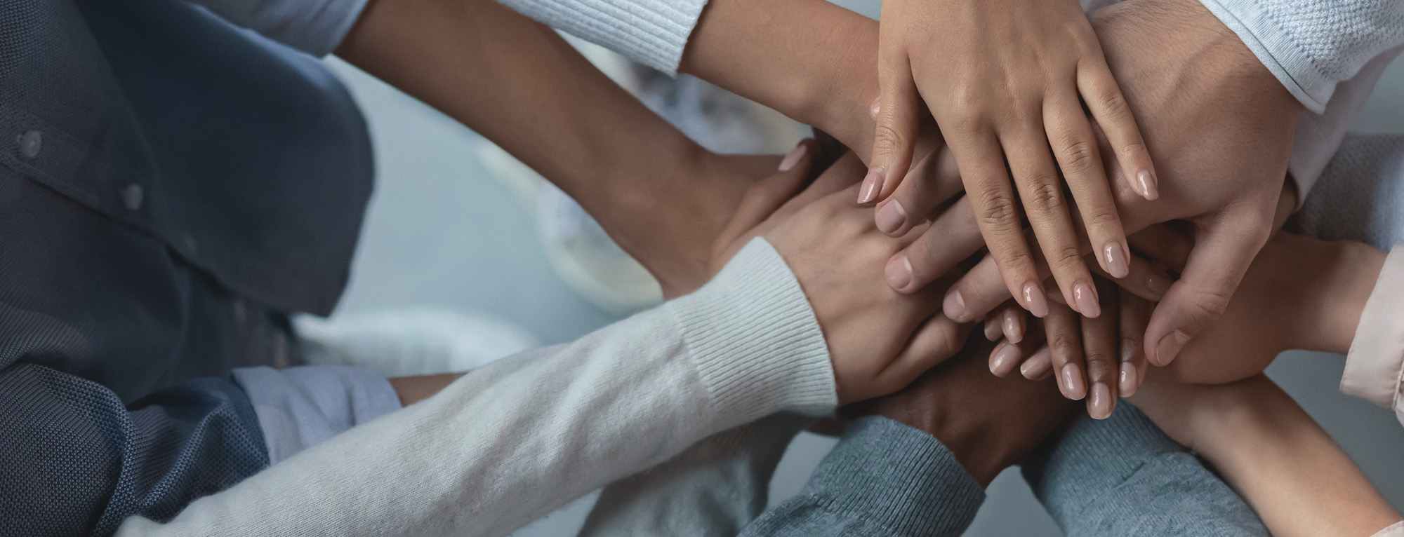 Personen eines Teams legen die Hände aufeinander