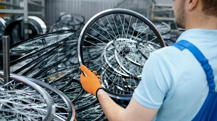 Arbeiter hält Vorderrad eines Fahrrads in der Hand