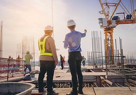 Bauherr und Architekt stehen auf einer Baustelle