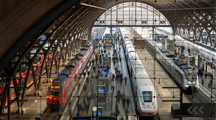 Gleise eines Bahnhofs mit Zügen und Personen