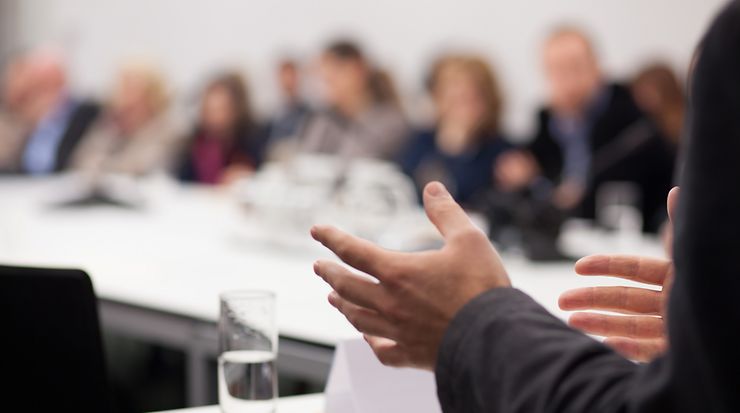 Szene aus einer Konferenz mit Personen in einem Konferenzraum