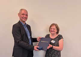 Dirk Kostmann (DIN) überreicht Dr. Ute Kalbe (rechts) den DIN-Exzellenz-Preis