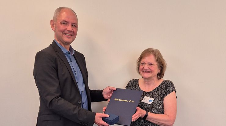 Dirk Kostmann (DIN) überreicht Dr. Ute Kalbe (rechts) den DIN-Exzellenz-Preis
