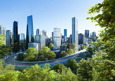 Moderne Stadt mit wolkenkratzenden Gebäuden, umgeben von Bäumen und grünen Landschaften.