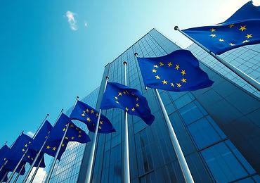 EU-Flaggen wehen vor einem modernen Glasgebäude