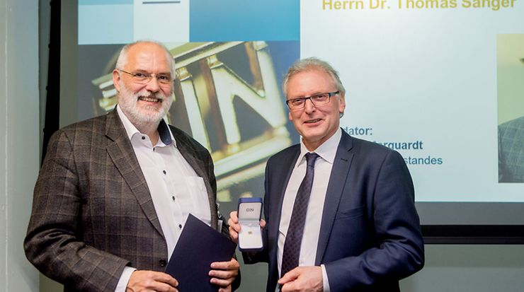 Rüdiger Marquardt (rechts) überreichte die DIN-Ehrennadel an Dr. Thomas Sänger