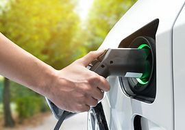 Person lädt ein Elektroauto auf