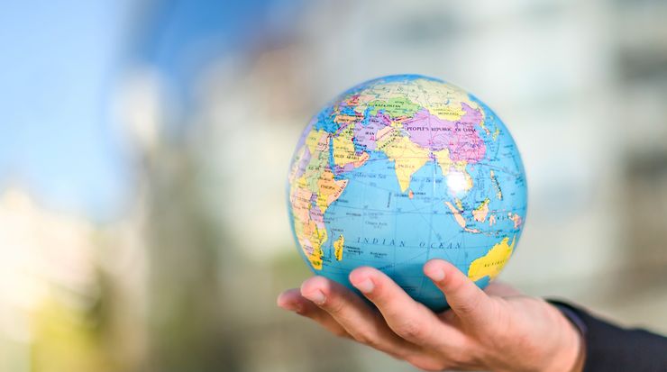 Ein Mann hält einen Globus in der Hand