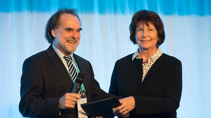 Übergabe der DIN-Ehrennadel von Frau Dr. Heinrich an Herrn Dr. Uwe Oelmüller 