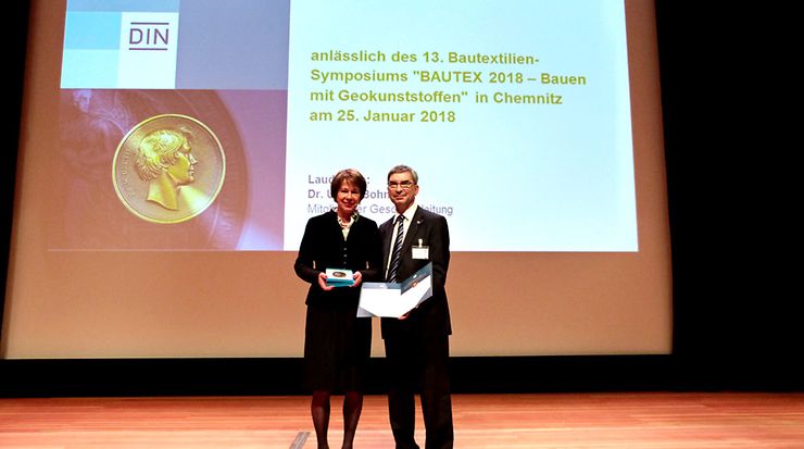 Frau Dr. Bohnsack, Mitglied der Geschäftsleitung bei DIN, übergibt die Beuth Denkmünze an Dr.-Ing. Matthias Mägel