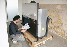 Person mit einer Gebrauchsanleitung beim Zusammenbau eines Kamins