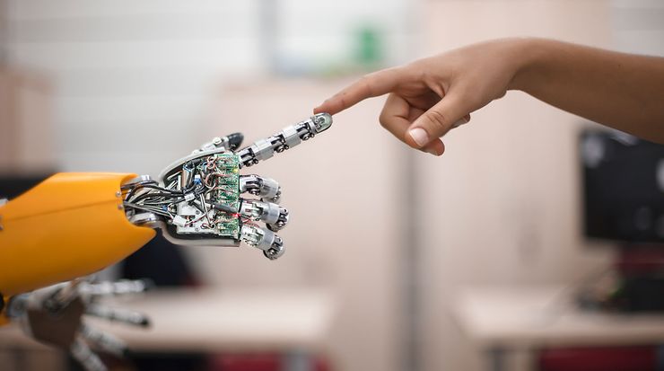 Finger eines Roboters berührt Finger eines Menschen