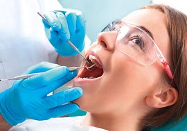 Frau wird von einem Zahnarzt operiert