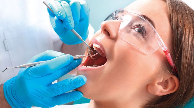 Frau wird von einem Zahnarzt operiert