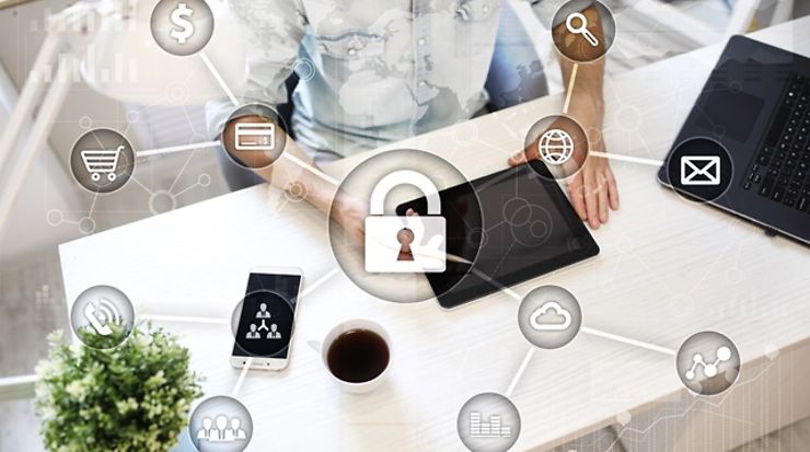 Person am Schreibtisch, Grafik mit Sicherheitsschloss im Vordergrund