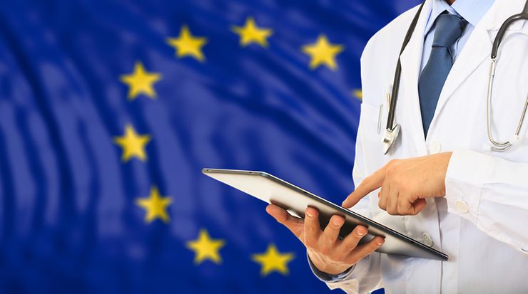 Arzt mit Tablet. Im Hintergrund Europa Flagge