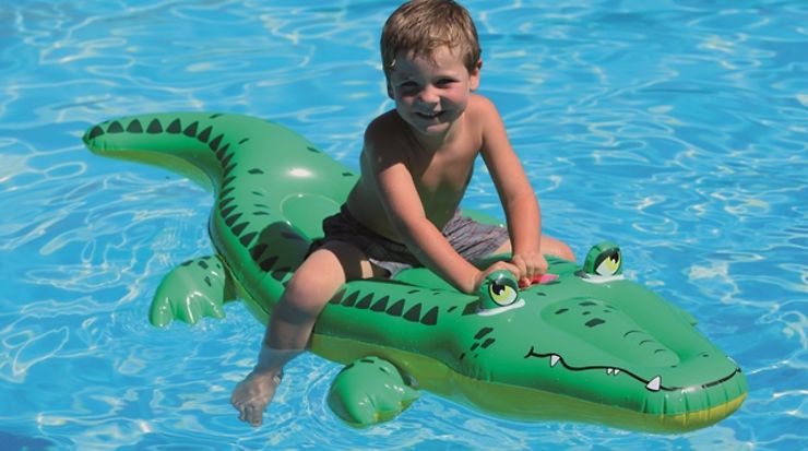 Kleinkind auf einem schwimmenden Freizeitartikel Krokodil 