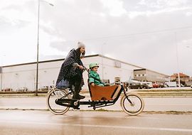 Mutter mit Kind auf einem Lastenfahrrad