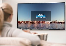 Person vor einem Fernseher sitzend