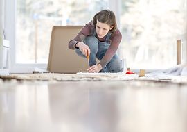 Person beim Aufbau von Möbeln nach Bauanleitung