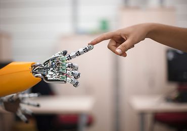 Finger Roboter berührt Finger eines Menschen
