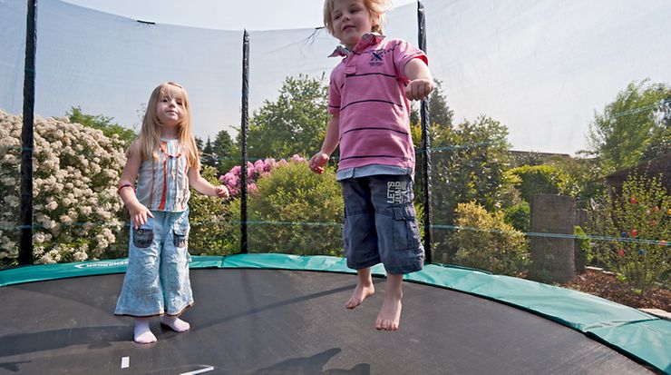 Kinder springen auf einem Trampolin