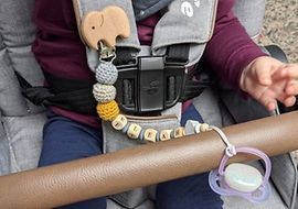 Baby mit Schnullerkette im Kinderwagen