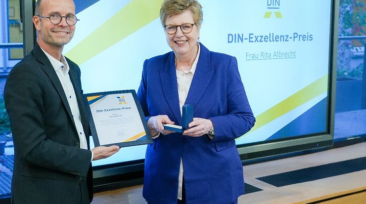 Volker Seibicke, Leiter der Abteilung Industrie und Informationstechnik (IIT), überreichte Rita Albrecht den DIN-Exzellenz-Preis